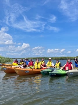 people sitting on kayaks in the water