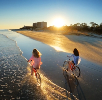two people biking on the beach