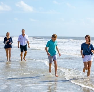 family splashing in the water on the beach