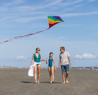 family flying a kite on the beach