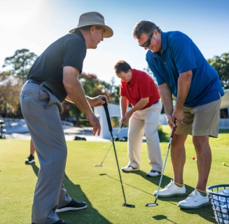 Golf instructor at Palmetto Dunes Golf Academy teaching proper form to two students