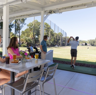 group of people at a driving range