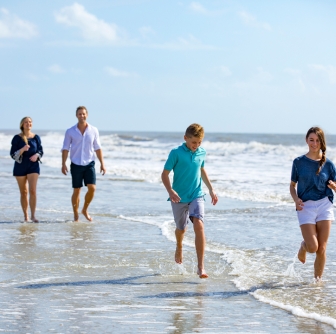 family splashing in the water on the beach 