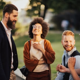 Smiling business people outdoors in the street on coffee break