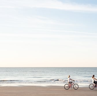 people biking on the beach