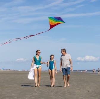 family flying a kite on the beach