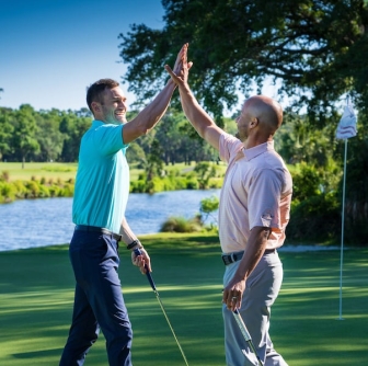 two male golfers high fiving on the George Fazio Golf Course