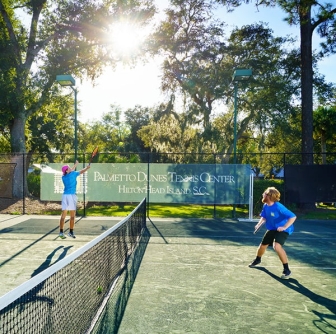two men actively playing tennis at Palmetto Dunes Tennis Center