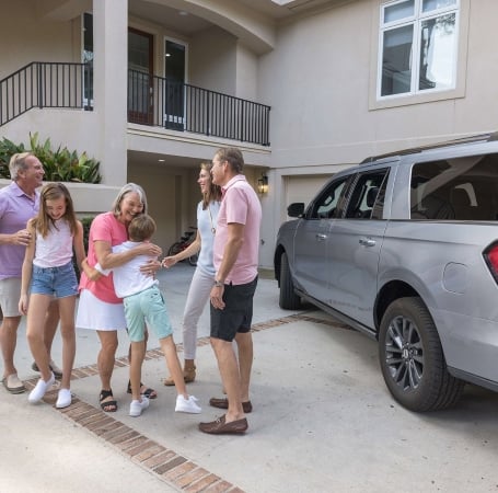 a multigenerational family standing outside of a vacation home