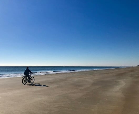 man on bike on beach