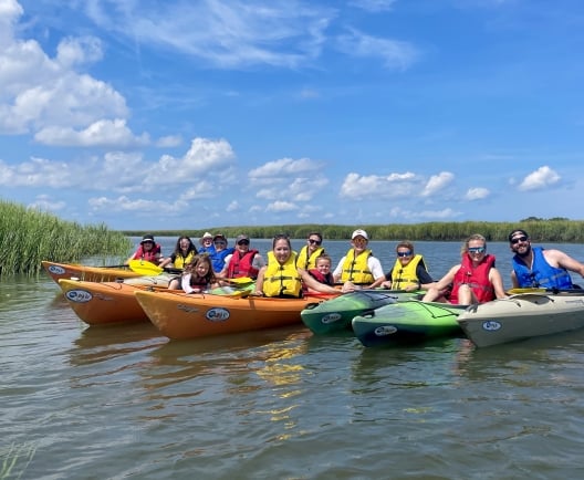 people sitting on kayaks in the water