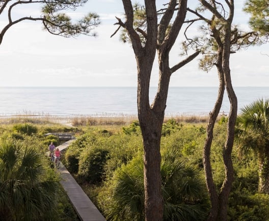 people walking on boardwalk away from beach 