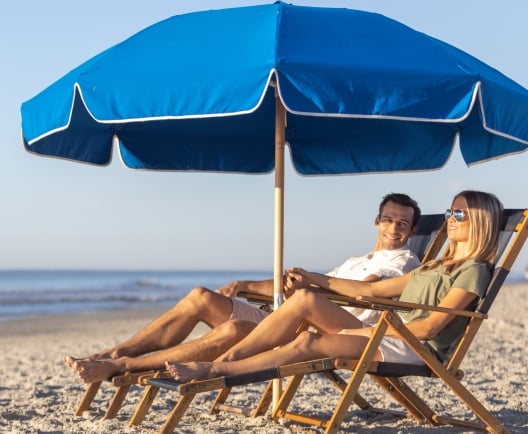 beach chairs and umbrella couple