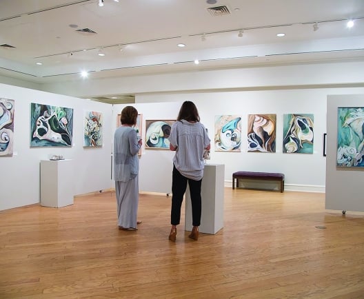 Two people standing in an art gallery