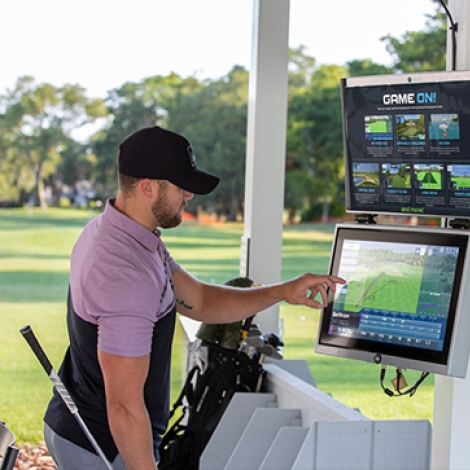 Man setting up a golf simulator.