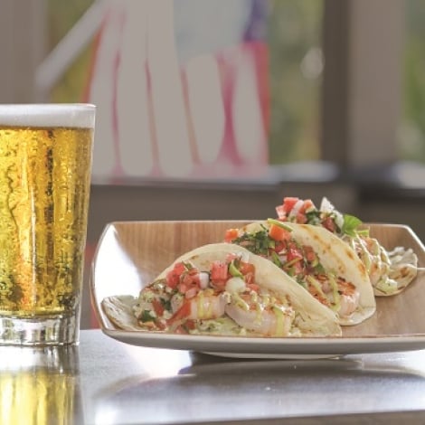 tacos on a table with a beer