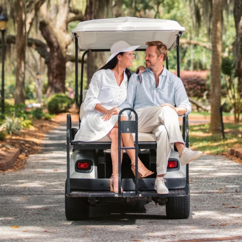 couple riding on the back of a golf cart