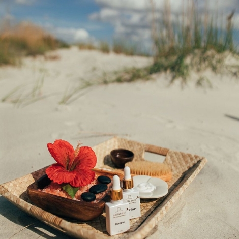 spa products on a stay on the beach with a red flower