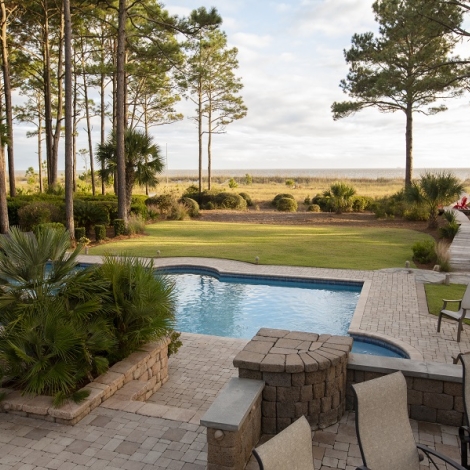 vacation home back yard with in ground pool and pathway leading to the beach