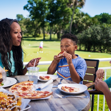 family eating food at a golf course