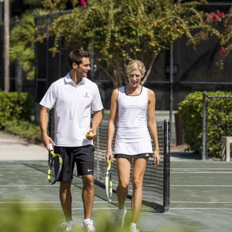 Two people walking on the tennis court 