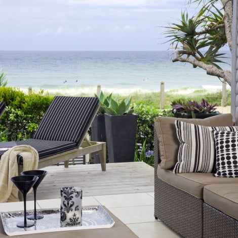 patio looking out at the beach with patio furniture 