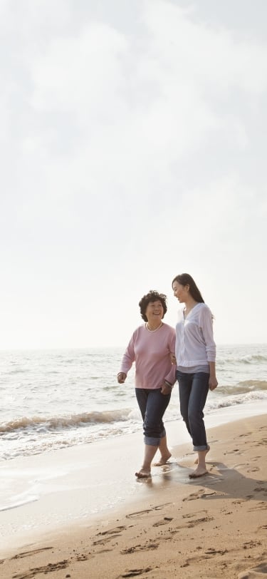 TWO PEOPLE WALKING ON THE BEACH