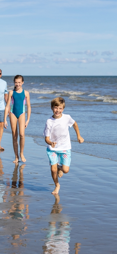 family running on the beach