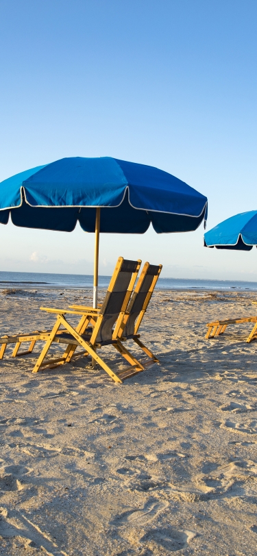 beach chairs with blue umbrellas lined up