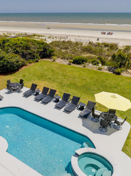 Pool with beach in the background of a vacation home