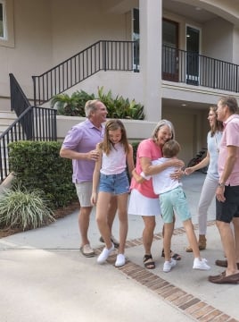 a multigenerational family standing outside of a vacation home