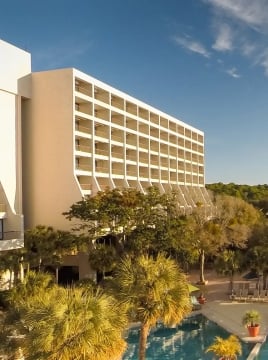 two large buildings with balconies overlooking a pool and the beach