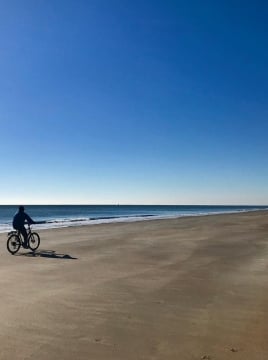 man on bike on beach
