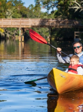 man and child kayaking 