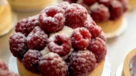A tart with raspberries covered in sugar.
