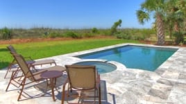 A backyard pool with lounge chairs.