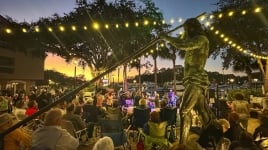 Band plays outside at night circled by their audience