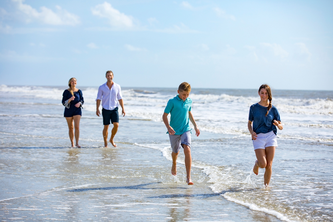 family splashing in the water on the beach 