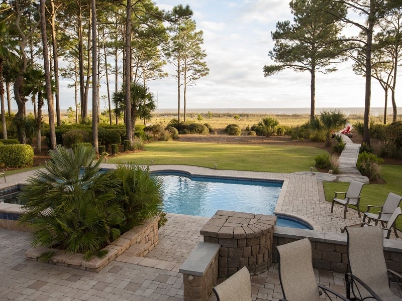 vacation home back yard with in ground pool and pathway leading to the beach