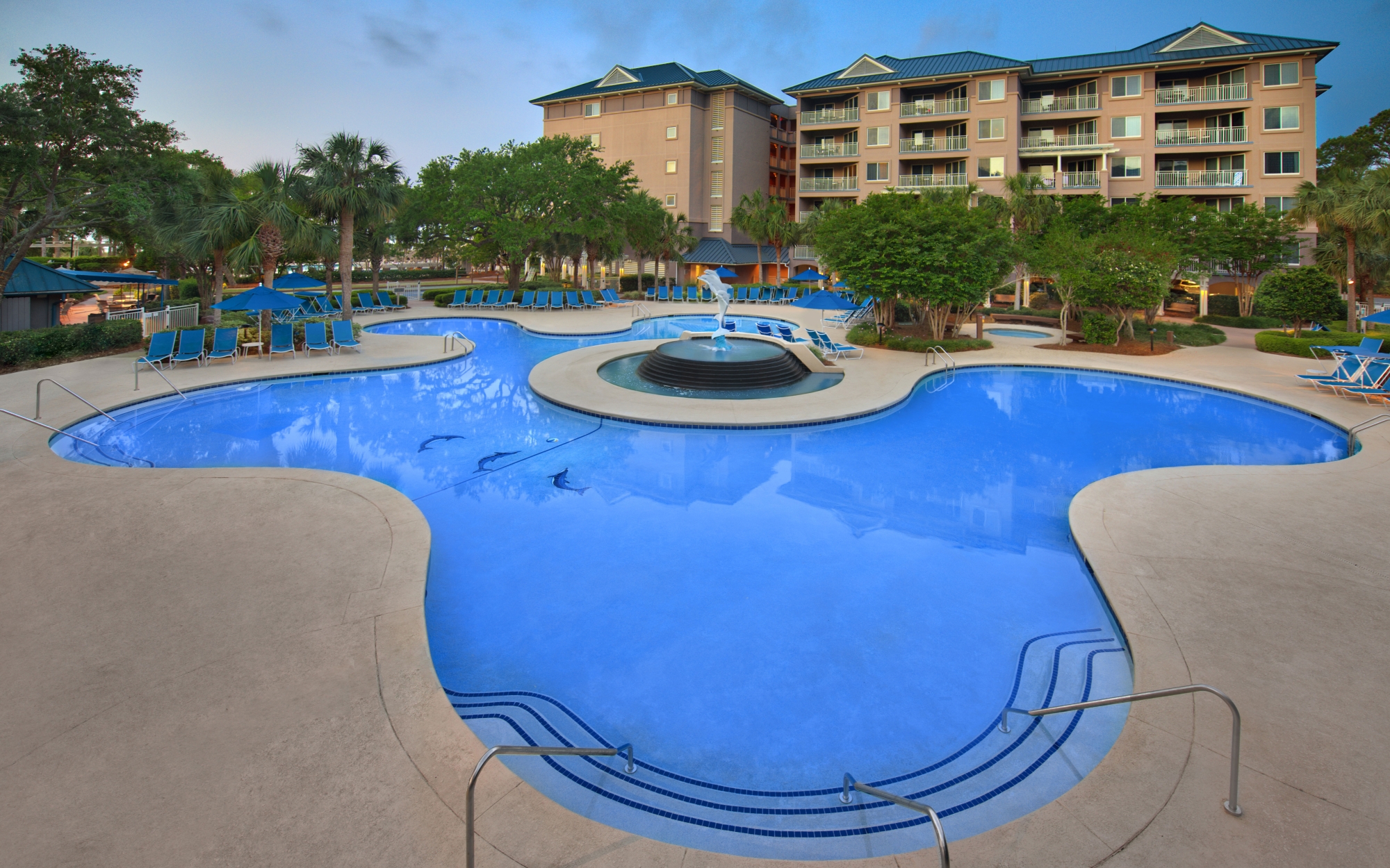 Dolphin Pool with property building in background. Shallow pool area with steps and rails. 