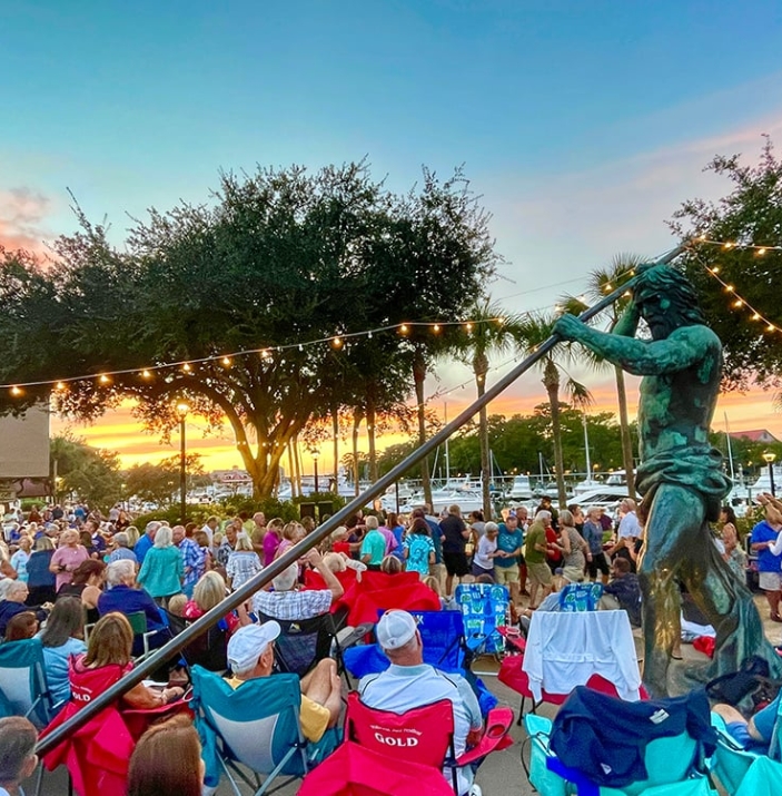 large group of people outdoors listening to music