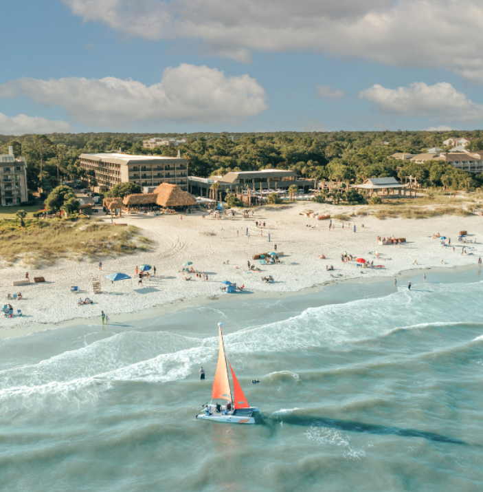 Coastal Savings - BHHHI Resort And Beach Aerial With Sailboat