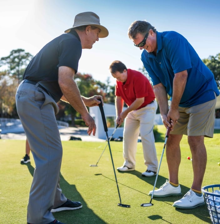 Golf instructor at Palmetto Dunes Golf Academy teaching proper form to two students