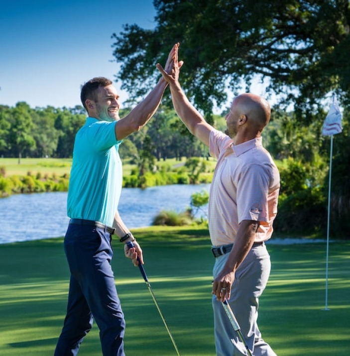 two male golfers high fiving on the George Fazio Golf Course